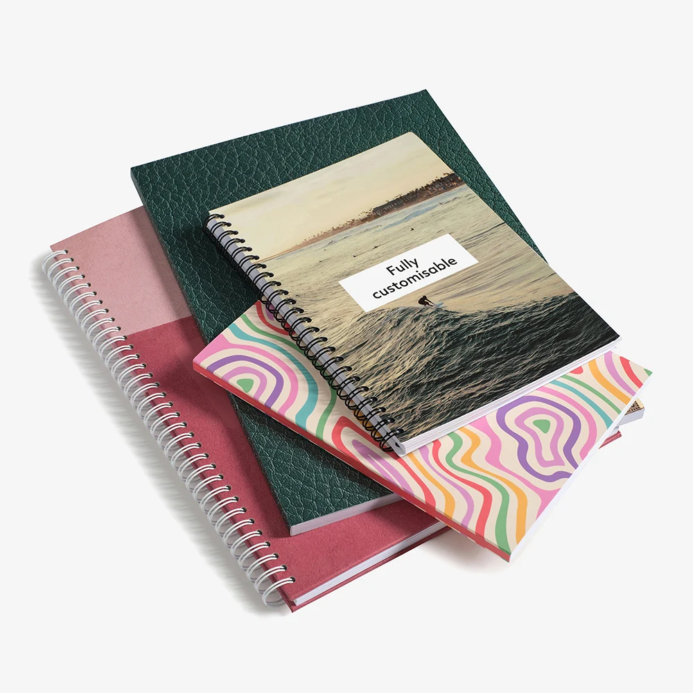A stack of notebooks showing various bindings and cover types